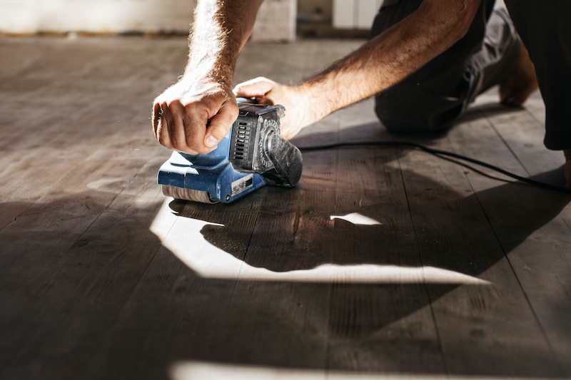 man sanding floor